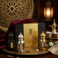 Three perfume bottles with a gold box on a decorative tray, with a warm and elegant background.